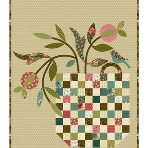 May include: A patchwork quilt pattern featuring a green plant with pink flowers and a blue bird in a brown and white checkered basket. The pattern is called "Patchwork Basket" and is a wallhanging pattern measuring 17 1/2 inches by 21 1/2 inches. The text "Laundry Basket Quilts" is also included.