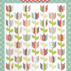 May include: A quilt pattern titled #119 Tulip Market by Coriander Quilts. The design features rows of pieced tulips in various floral and striped fabrics with green stems and leaves on a white background, framed by a light green border.