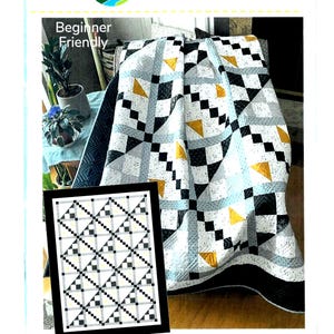 May include: A quilt with a geometric pattern in black, white, gray, and gold. The quilt is labeled "Diamond Mist" and is described as "Beginner Friendly." The image also includes a framed picture of the quilt's pattern.