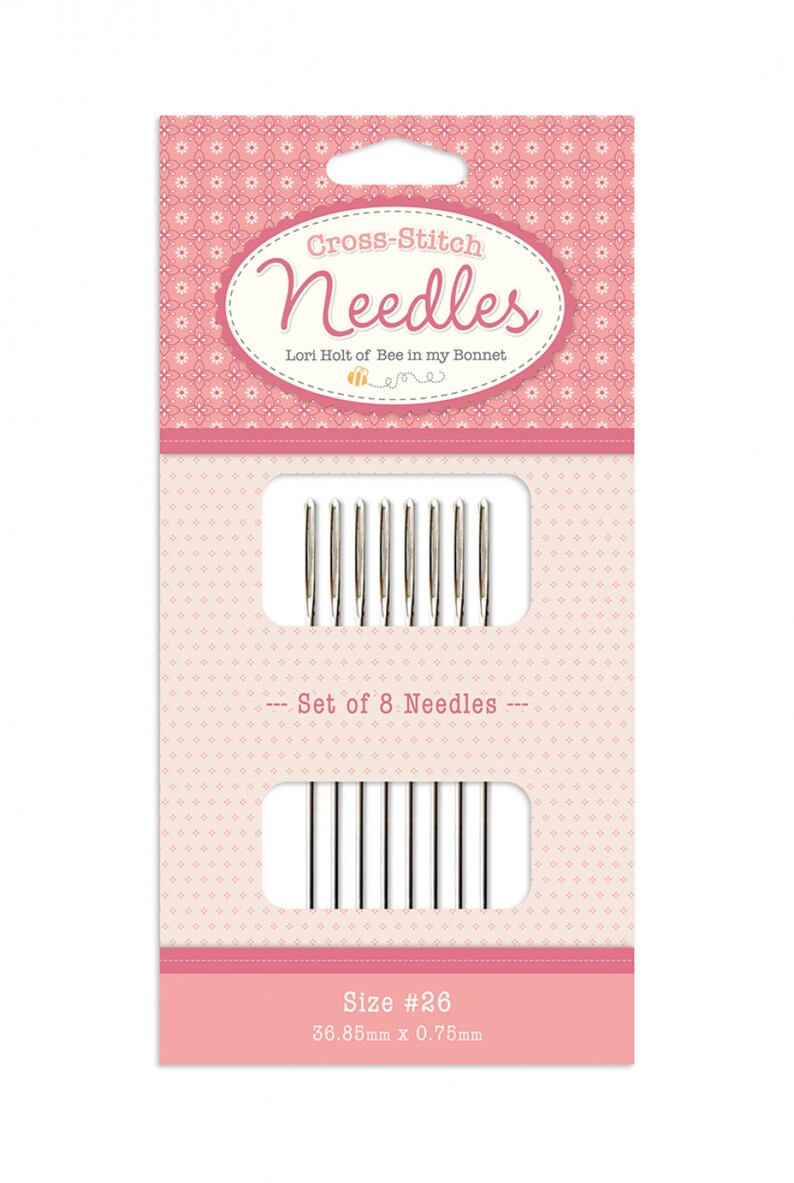 Puede incluir: Un juego de 8 agujas de punto de cruz en un paquete rosa y blanco. Las agujas son de tama&ntilde;o #26, 36,85 mm x 0,75 mm. El paquete presenta un dise&ntilde;o de abeja y el texto "Cross-Stitch Needles" y "Lori Holt of Bee in my Bonnet".