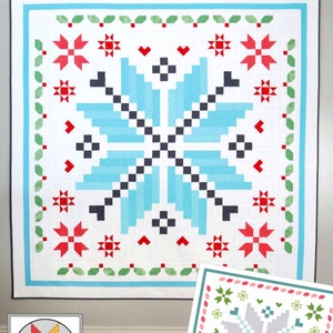 May include: A white quilt with a blue snowflake design in the center. The snowflake is surrounded by red and green accents. The quilt is titled "Winter Magic".