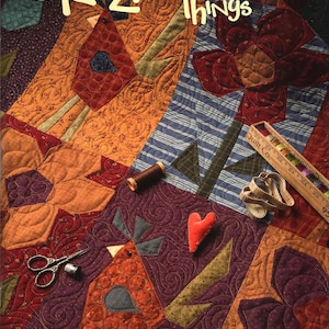 May include: A colorful quilt with the text "Crazy Favorite Things" features bird and flower designs in shades of orange, red, blue, and purple. Sewing notions like scissors, a spool of thread, and a ruler are scattered across the quilt.