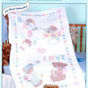 May include: A white crib quilt top with a baby bear theme. The quilt features a blue airplane with two bears, a sun, a butterfly, and the words "Baby Love". The quilt is 40 inches by 60 inches and is made of cotton and poly broadcloth.