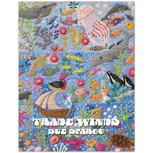 May include: A colorful quilt featuring an underwater scene with various marine life, including whales, fish, seahorses, and a jellyfish. The quilt has the text "Trade Winds" and "Sue Spargo" at the bottom. The background is blue.