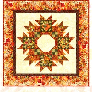 May include: Autumn Celebration Wreath quilt pattern featuring a wreath design with fall leaves, pumpkins, and gourds in shades of orange, brown, green, and gold. The pattern is by Jason Yenter.