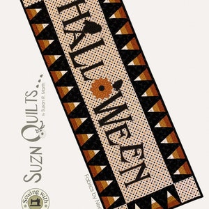 May include: A Halloween themed table runner with a black and orange color scheme. The runner features a black and white "Hall Ween" text with a black and orange candy corn border. The runner is 17 inches by 47 inches.