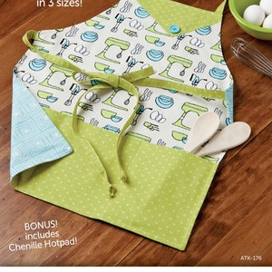May include: A green and blue apron with a white background and a pattern of kitchen mixers and bowls. The apron has a pocket and ties. The text "Mom and Me Aprons in 3 sizes!" is at the top of the image. The text "BONUS! includes Chenille Hotpad!" is at the bottom of the image. The text "ATK-176" is in the bottom right corner of the image.