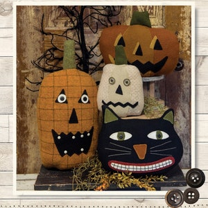 May include: A set of three felt pumpkin and one black cat Halloween decorations. The pumpkins are orange and white with black eyes and mouths. The cat has black felt with white eyes and a orange nose. The set is labeled "3 Jacks & A Cat" and "Size: Sizes Vary".