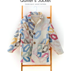 May include: A pieced quilt jacket pattern titled Laundry Basket Quilts Quilter's Jacket. The jacket features a quilted texture with a multi-colored geometric pattern in blue, pink, and yellow on a cream background, three brown buttons, and two front pockets.