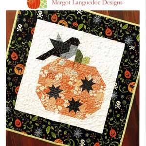 May include: A quilted Halloween-themed table runner featuring a pumpkin and bird design. The pumpkin is orange with black star accents, and the bird is black and gray. The border is black with pumpkins, spiders, and skulls. Text reads "Pumpkin Season".