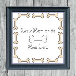 May include: A white framed sign with a black border and the text "Leave Room for the Bone Lord" in a decorative font. The sign is surrounded by a border of beige bone-shaped graphics.