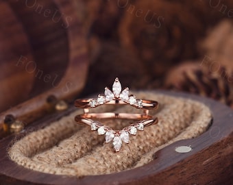 May include: Rose gold ring enhancer with a marquise shaped diamond crown design. The enhancer is made of metal and has a delicate, feminine look.