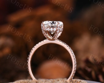 May include: A rose gold engagement ring with a large, round, clear center stone surrounded by smaller diamonds. The band is also set with diamonds.