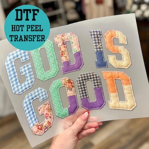May include: A heat transfer sheet with the words "GOD IS GOOD" in patchwork letters. The letters are in various patterns and colors, including gingham, floral, and solid colors. The words "DTF HOT PEEL TRANSFER" are in a teal circle.