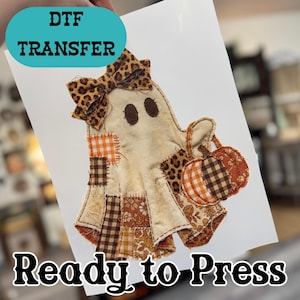 May include: A DTF transfer sheet featuring a ghost illustration with a leopard print bow, holding a pumpkin. The ghost has patches of orange gingham, brown plaid, and floral fabric patterns. The text DTF TRANSFER and Ready to Press is visible.