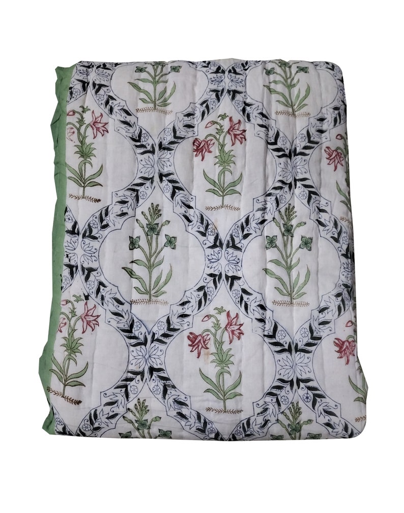 Puede incluir: Edred&oacute;n de algod&oacute;n blanco con un patr&oacute;n floral negro y verde. El edred&oacute;n tiene un borde verde y est&aacute; acolchado en forma de diamante.