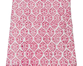 May include: A pink and white cotton quilt with a geometric pattern. The quilt is folded and has a white background with a pink floral design.