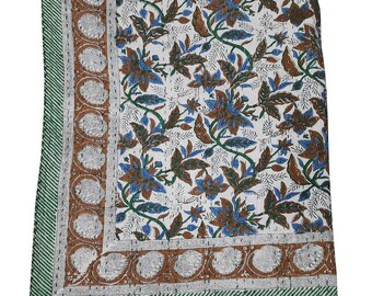 Puede incluir: Una colcha de algodón blanco con un patrón floral en tonos marrones y azules. La colcha tiene un borde verde y marrón.