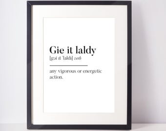 Puede incluir: Impresión enmarcada con texto negro "Gie it laldy" sobre fondo blanco. También se incluye la definición y la pronunciación fonética. El marco es negro.