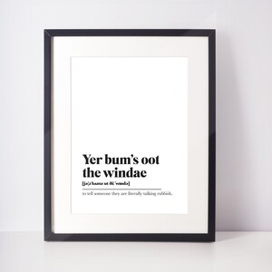 Peut inclure: Impression encadrée noire avec l'expression "Yer bum's oot the windae" en noir. La définition en dessous indique "dire à quelqu'un qu'il raconte littéralement des bêtises."