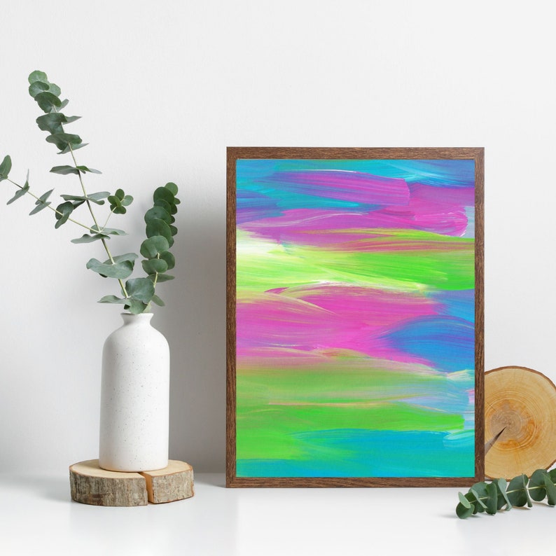 Puede incluir: Pintura abstracta con pinceladas horizontales en tonos de rosa, verde, azul y morado. La pintura est&aacute; enmarcada en un marco de madera marr&oacute;n.