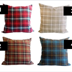 Op de afbeelding: Vier vierkante kussens met verschillende ruitpatronen. De kussens zijn rood en wit, bruin en wit, rood en bruin en blauw en bruin.