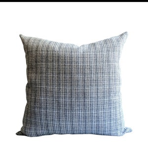 Op de afbeelding: Een vierkant kussen met een blauw-wit patroon.