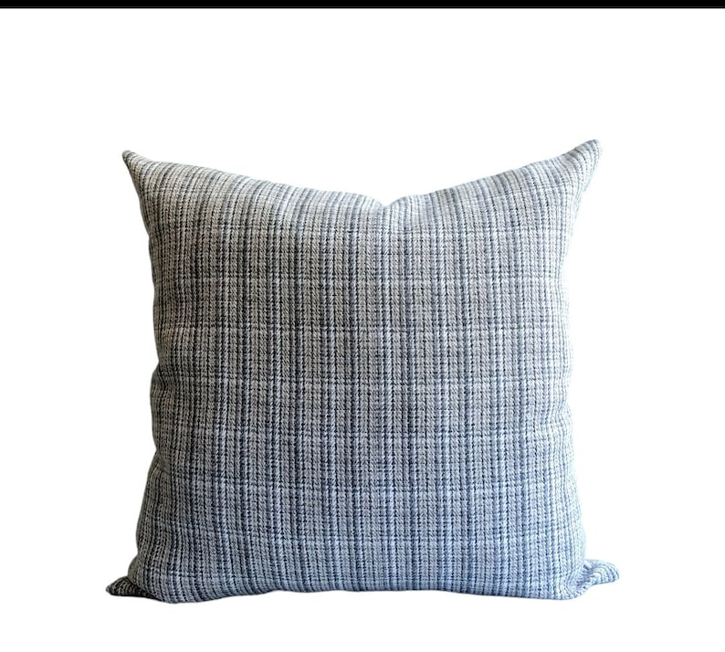 Op de afbeelding: Een vierkant kussen met een blauw-wit patroon.