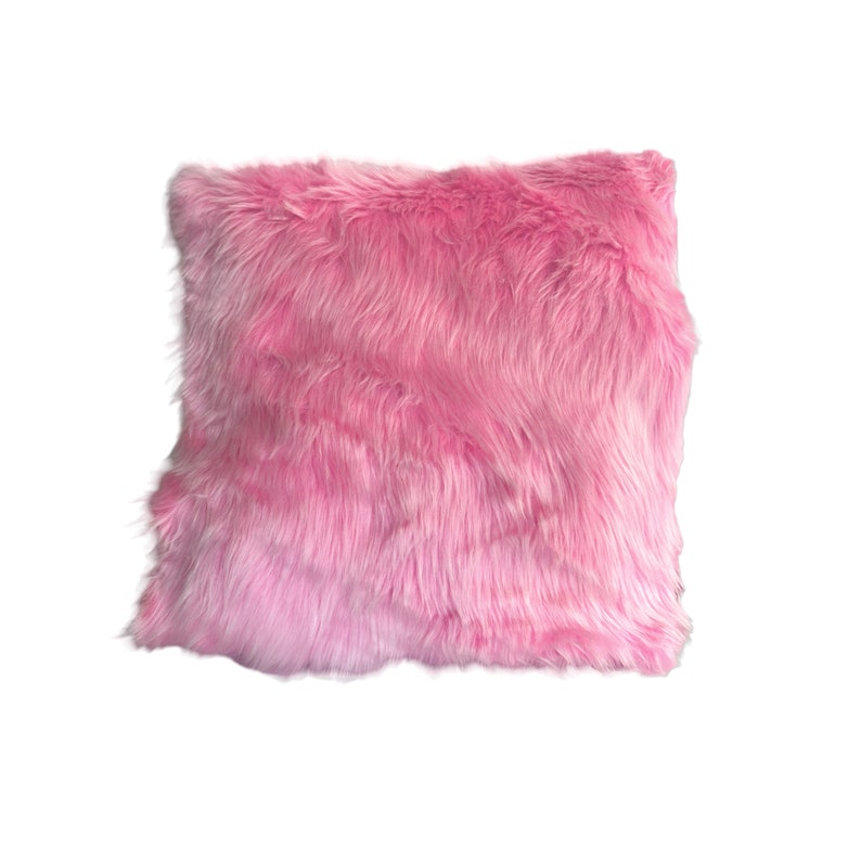 Puede incluir: Una almohada de color rosa suave y esponjosa con una textura suave y peluda.