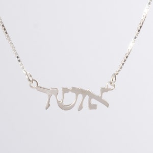 May include: A silver chain necklace with a pendant that says "שלום" in Hebrew.
