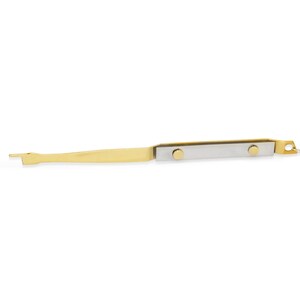May include: A gold-colored metal tool with a pointed end and a flat, rectangular section with two gold-colored rivets. The tool is designed for opening and closing items.