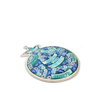 K&ouml;nnte beinhalten: Eine blaue und wei&szlig;e Keramikgranate mit hebr&auml;ischem Text und floralen Designs. Der Granatapfel ist ein Symbol f&uuml;r F&uuml;lle und Wohlstand in der j&uuml;dischen Kultur.