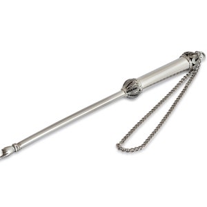 May include: A silver yad, a Jewish ceremonial pointer, with an ornate design and a chain attached to the top.
