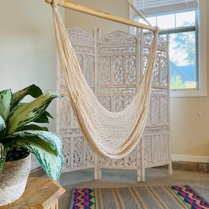 boho swinging chair indoors with a colorful rug