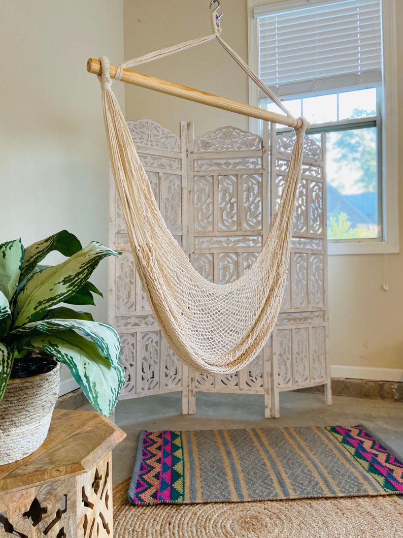 boho swinging chair indoors with a colorful rug