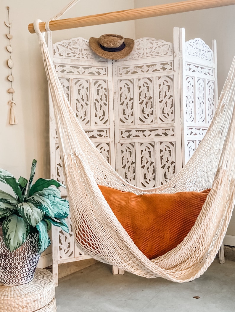 woven rope macrame swing with an orange pillow