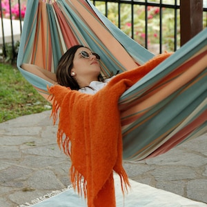 woman resting on a hammock outside backyard