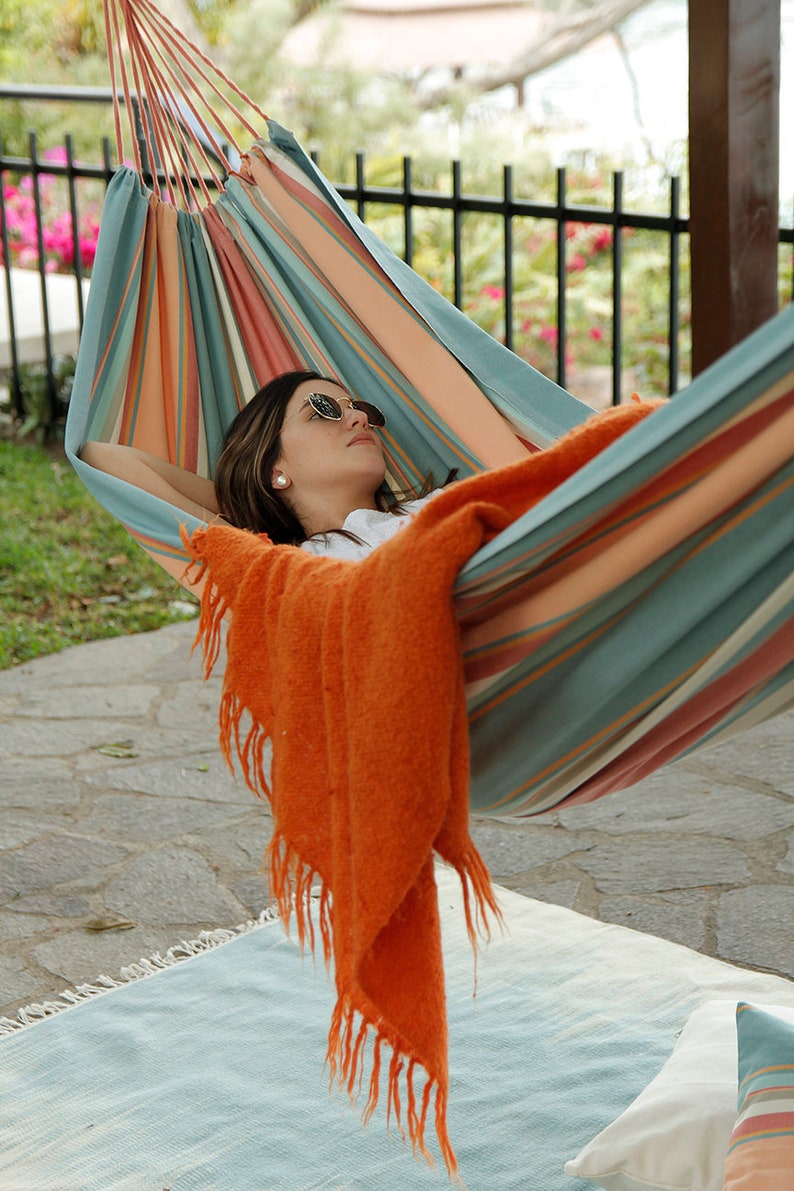 woman resting on a hammock outside backyard