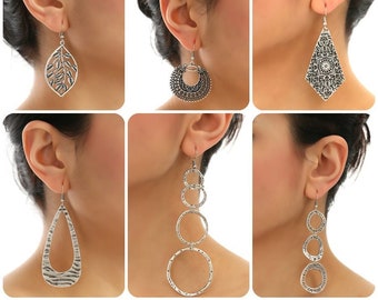 May include: Six different silver earrings with various designs, including a leaf, a circle, a teardrop, and a geometric shape.