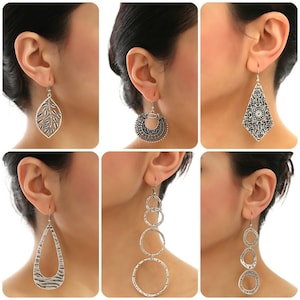 May include: Six different silver earrings with various designs, including a leaf, a circle, a teardrop, and a geometric shape.