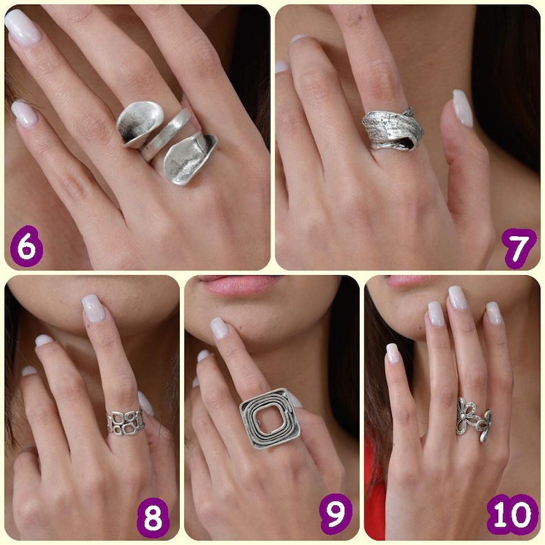 May include: Five different silver rings on a hand. The rings are all unique in design and style.