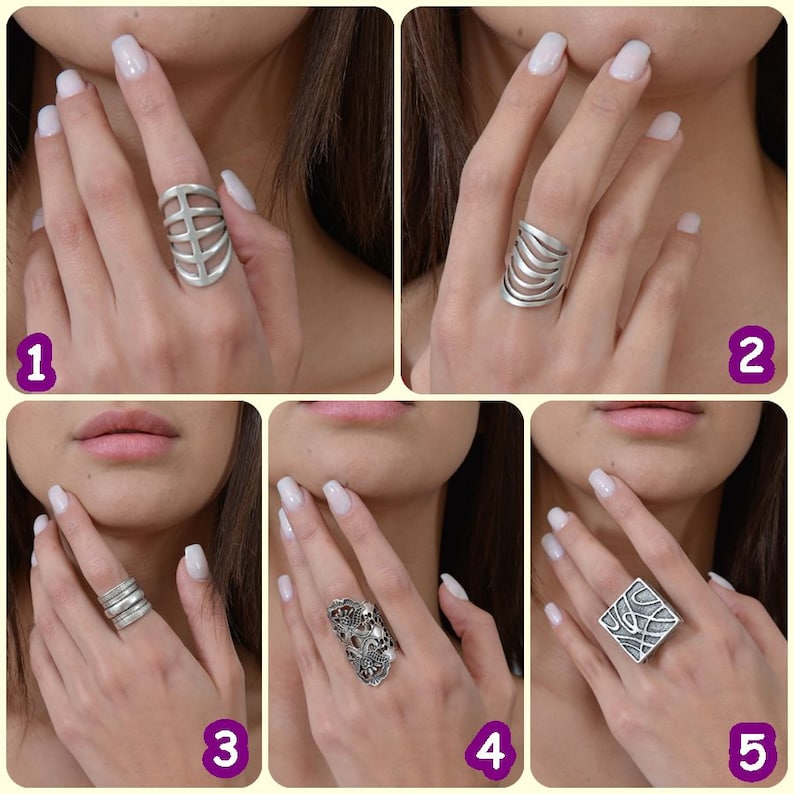 May include: Five different silver rings with unique designs. The rings are shown on a model's fingers.