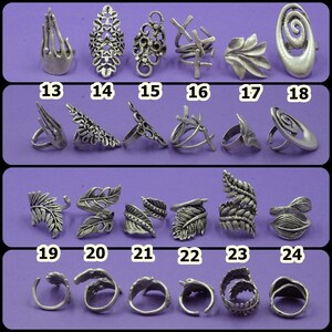 May include: Set of 24 silver-toned rings with various designs, including leaf, spiral, and geometric patterns. The rings are numbered 13 through 24.