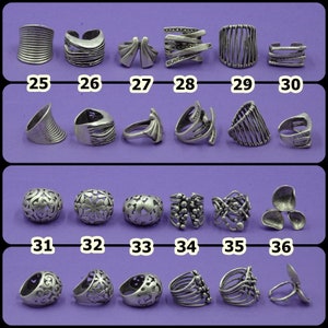May include: A collection of 36 silver rings with various designs. The rings are arranged in rows of six, with numbers 25 through 36 below each row.