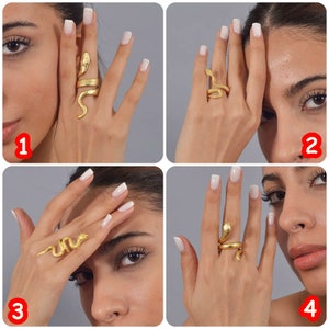 May include: A gold-toned snake ring with a coiled design. The ring is shown on a model's finger in four different positions.