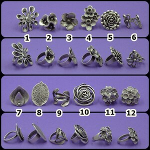 May include: Twelve silver-toned rings with various floral and leaf designs. The rings are arranged in four rows of three. The rings are all different sizes and shapes.