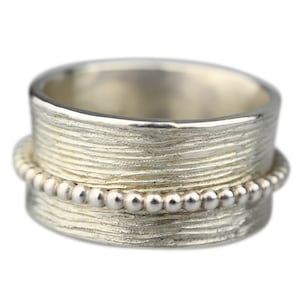 Fluted silver ring with rotating bead rail