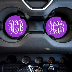May include: Two purple car coasters with white monogram initials "C.B." in a decorative script font.