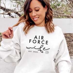 May include: White sweatshirt with black text that reads "Air Force Wife Est. 2022".