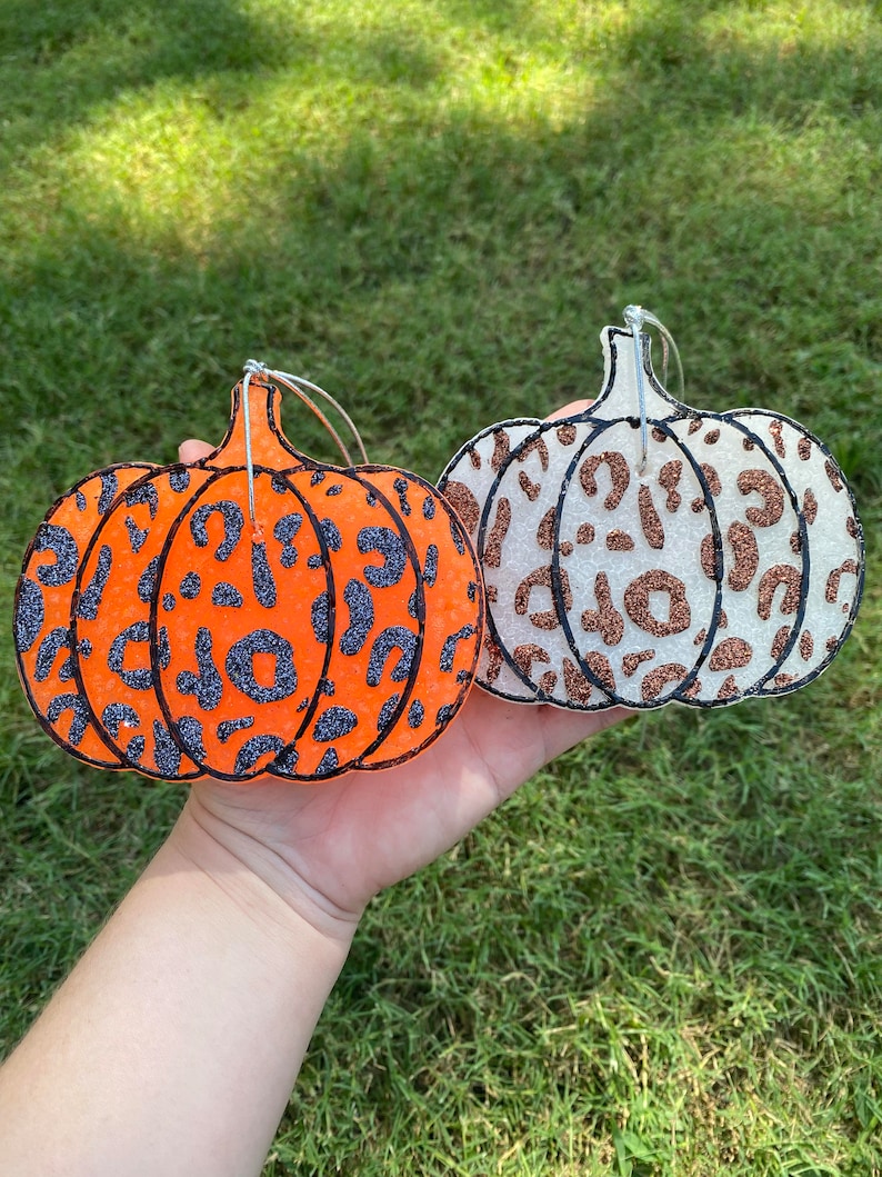 Pu&ograve; includere: Due decorazioni a forma di zucca con stampa leopardata glitterata. Una &egrave; arancione con macchie glitterate nere, l'altra &egrave; bianca con macchie glitterate marroni. Entrambe hanno ganci in filo d'argento.
